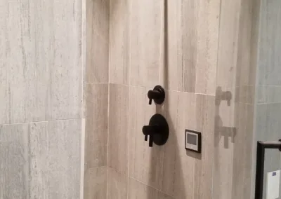 A bathroom with a shower stall and a shower head.