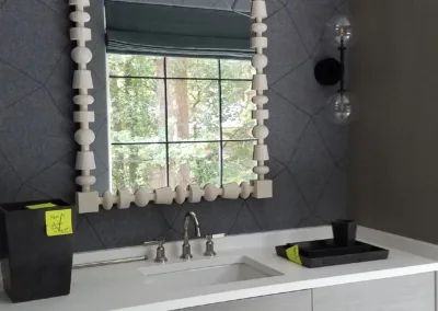 A bathroom with a gray vanity and mirror.