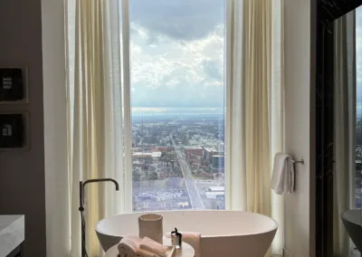 A large bathroom with a view of the city.