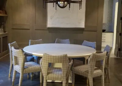 A dining room with a round table and chairs.