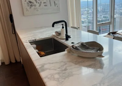 A kitchen with marble counter tops and a sink.