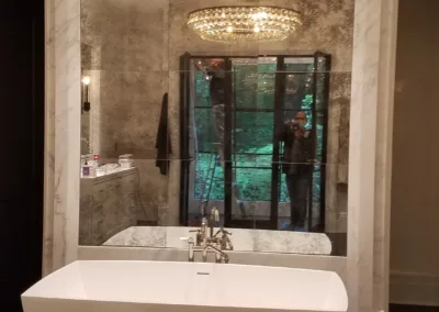 A bathroom with a large tub and mirror.