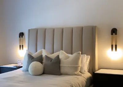 A modern bedroom with a bed and two lamps.