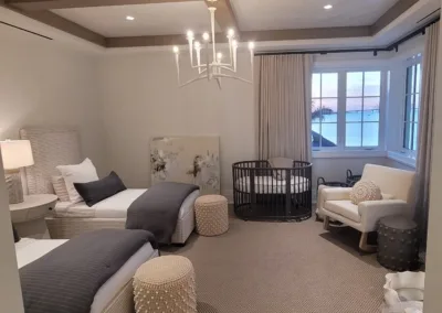 A bedroom with two beds and a chandelier.