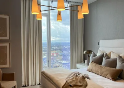 A bedroom with a large bed and a view of the city.