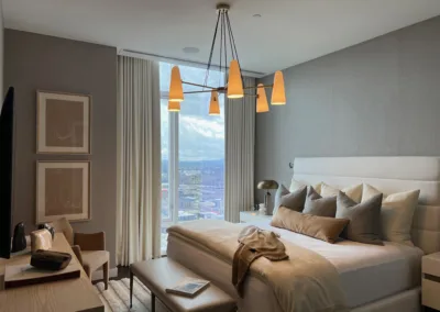 A bedroom with a large bed and a view of the city.