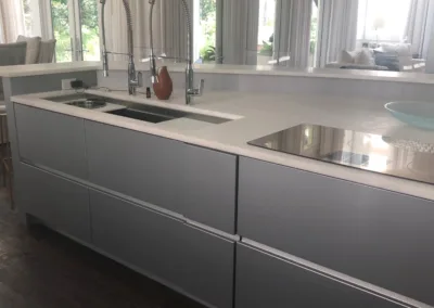 A kitchen with white cabinets and sink.